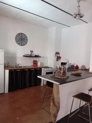 a kitchen with a table and a clock on the wall at La maison du bonheur in Ville-di-Paraso