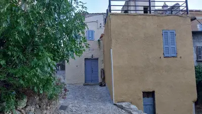 a building with a blue door on the side of it at La maison du bonheur in Ville-di-Paraso