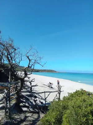 a beach with two people on the sand and the ocean at La maison du bonheur in Ville-di-Paraso