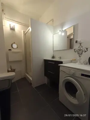 a bathroom with a washing machine and a sink at La maison du bonheur in Ville-di-Paraso