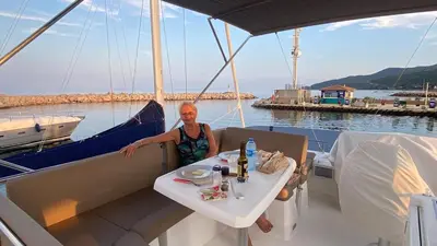 a woman sitting at a table on a boat at luxueux bateau à quai in Sari Solenzara