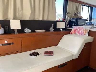 a bench in a room with a table and two lamps at luxueux bateau à quai in Sari Solenzara