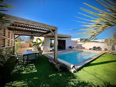a backyard with a pool and a table and a house at Villa proche Saint Cyprien et Cala Rossa in Lecci