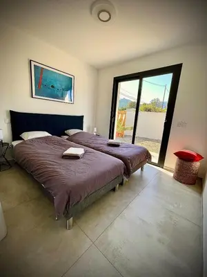 a bedroom with a large bed with a large window at Villa proche Saint Cyprien et Cala Rossa in Lecci