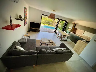 a living room with a couch and a living room with a pool at Villa proche Saint Cyprien et Cala Rossa in Lecci