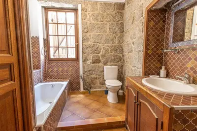 a bathroom with a tub and a toilet and a sink at L'OMU DI CAGNA in Sartène