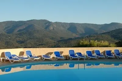 a row of chairs sitting next to a swimming pool at Grand F2 clim wifi lave linge vue mer résidence piscine mer à pied in Serra-di-Ferro