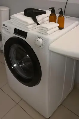 a white washing machine with towels on top of it at Grand F2 clim wifi lave linge vue mer résidence piscine mer à pied in Serra-di-Ferro