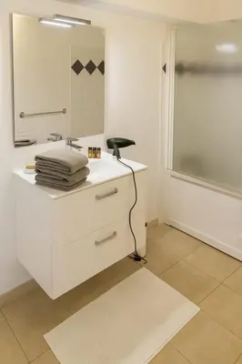 a white bathroom with a sink and a shower at Duplex vue mer avec clim wifi dans résidence piscine mer à pied in Serra-di-Ferro