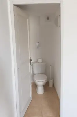 a bathroom with a toilet in a white room at Duplex vue mer avec clim wifi dans résidence piscine mer à pied in Serra-di-Ferro