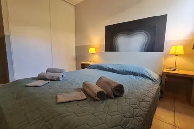 a bedroom with a bed with towels and two lamps at Appartement climatisé dans une résidence avec piscine mer à pied in Serra-di-Ferro
