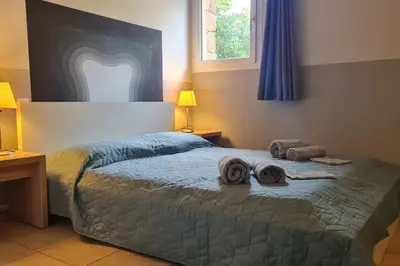 a bedroom with a bed with towels on it at Appartement climatisé dans une résidence avec piscine mer à pied in Serra-di-Ferro