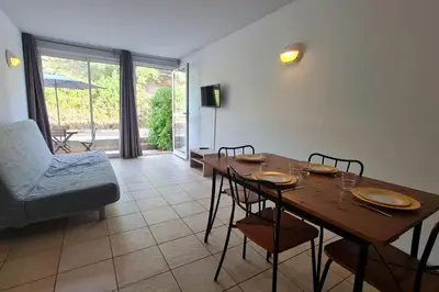 a dining room with a wooden table and chairs at Appartement climatisé dans une résidence avec piscine mer à pied in Serra-di-Ferro