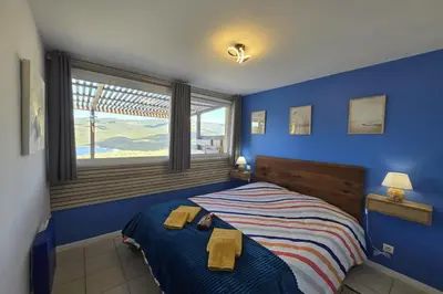 a blue bedroom with a bed with towels on it at Magnifique T2 terrasse vue mer panoramique dans résidence avec piscine in Serra-di-Ferro
