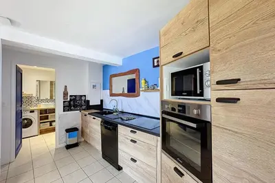 a kitchen with a stove and a microwave at Magnifique T2 terrasse vue mer panoramique dans résidence avec piscine in Serra-di-Ferro