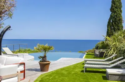 a garden with benches and a swimming pool at Villa 10 personnes avec piscine vue mer in Conca