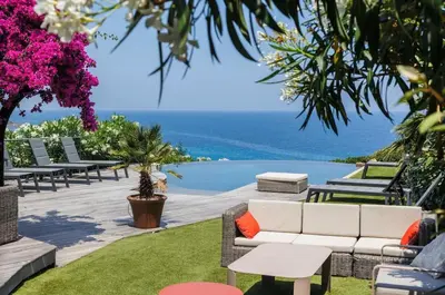 a patio with a couch and a view of the ocean at Villa 10 personnes avec piscine vue mer in Conca