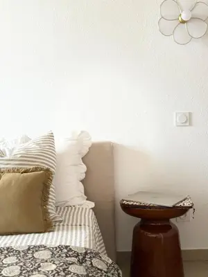 a bedroom with a bed with a flower on the wall at Appartement 2 CHAMBRES PISCINE TERRASSE SAINT FLORENT in Oletta