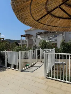 a white picket fence in front of a house at Appartement 2 CHAMBRES PISCINE TERRASSE SAINT FLORENT in Oletta