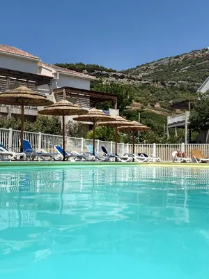 a swimming pool with chairs and umbrellas at Appartement 2 CHAMBRES PISCINE TERRASSE SAINT FLORENT in Oletta