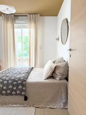 a bedroom with a bed with a mirror on the wall at Appartement 2 CHAMBRES PISCINE TERRASSE SAINT FLORENT in Oletta