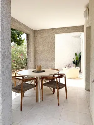 a dining room with a table and chairs at Appartement 2 CHAMBRES PISCINE TERRASSE SAINT FLORENT in Oletta