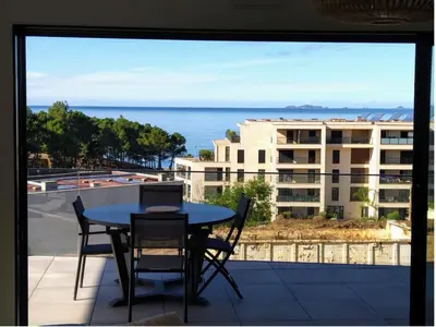 a table and chairs on a balcony with a view of the ocean at Appartement T3 Porticcio résidence les Jardins de Livia in Albitreccia