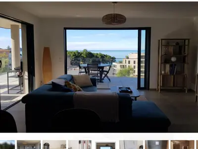 a living room with a couch and a view of the ocean at Appartement T3 Porticcio résidence les Jardins de Livia in Albitreccia