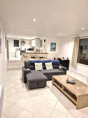 a living room with a couch and a table at rez de villa confort & grand extérieur in Furiani