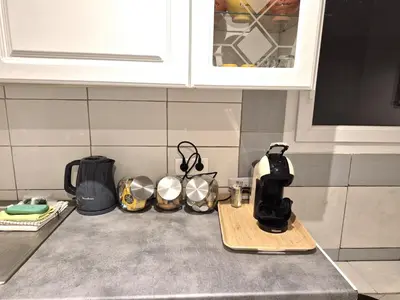 a kitchen counter top with a coffee maker and utensils at rez de villa confort & grand extérieur in Furiani