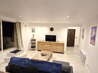 a living room with a couch and a tv at rez de villa confort & grand extérieur in Furiani