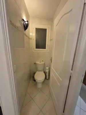 a small bathroom with a toilet and a window at rez de villa confort & grand extérieur in Furiani