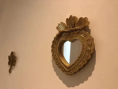 a gold mirror hanging on a wall with a cross at villa paisible de campagne avec piscine in Alata