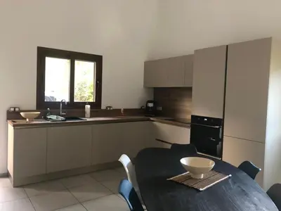 a kitchen with a table with chairs and a tableasteryasteryasteryasteryasteryastery at villa paisible de campagne avec piscine in Alata