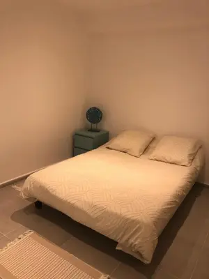 a bedroom with a bed and a lamp on a night stand at villa paisible de campagne avec piscine in Alata