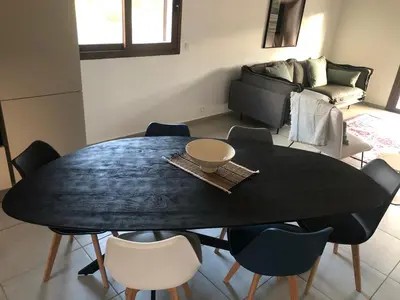 a dining room with a black table and chairs at villa paisible de campagne avec piscine in Alata