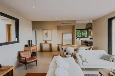 a living room with white furniture and a dining room at Villa Marina Di Porto-Vecchio in Porto-Vecchio