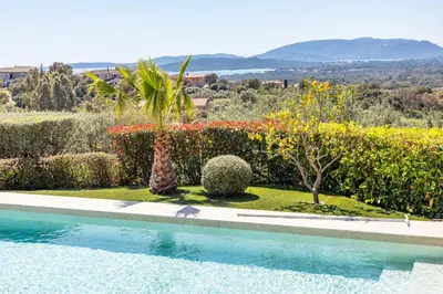 a swimming pool in front of a garden with trees and bushes at Villa Dolce Di Cirendinu in Sainte-Lucie de Porto-Vecchio