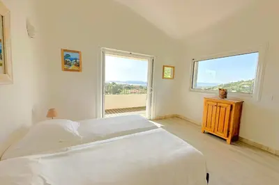 a bedroom with two beds and a large window at Villa Dolce Di Cirendinu in Sainte-Lucie de Porto-Vecchio