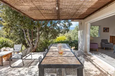 a patio with a table and chairs on a patio at Villa Dolce Di Cirendinu in Sainte-Lucie de Porto-Vecchio