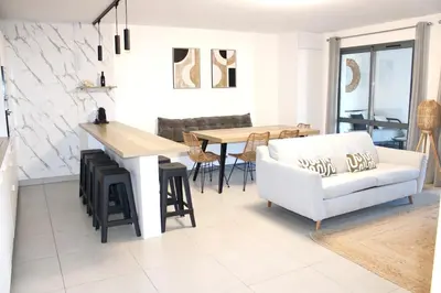 a living room with a table and a white couch at Superbe Appartement port de Bonifacio in Bonifacio