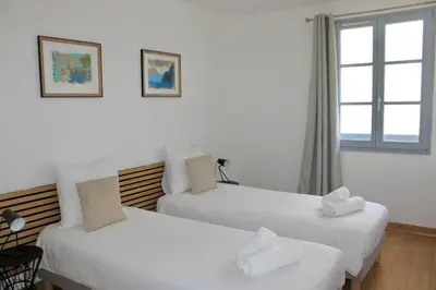 two white beds in a room with a window at Superbe Appartement port de Bonifacio in Bonifacio