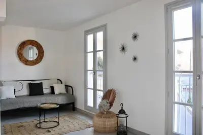 a living room with a couch and two windows at Superbe Appartement port de Bonifacio in Bonifacio