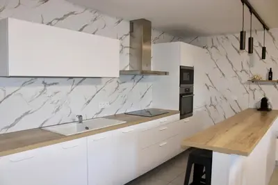 a white kitchen with a sink and a counter at Superbe Appartement port de Bonifacio in Bonifacio