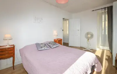 a bedroom with a bed and a desk and a fan at 3 Bedroom Awesome Apartment In Olmeto in Olmeto