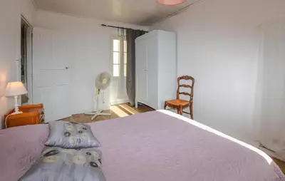 a bedroom with a large bed and a chair at 3 Bedroom Awesome Apartment In Olmeto in Olmeto
