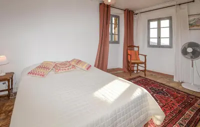 a bedroom with a white bed with pillows on it at 3 Bedroom Awesome Apartment In Olmeto in Olmeto