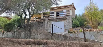 a house with a gate on a stone wall at Casa di l Ulivu in Porto Pollo