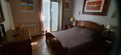 a bedroom with a bed and a table and a window at Casa di l Ulivu in Porto Pollo