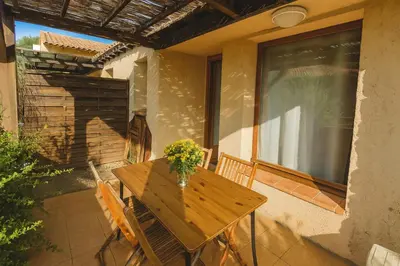 a wooden table and chairs on a patio at Mini-villa 4 personnes - Soléa 82 - vue nature in Serra-di-Ferro